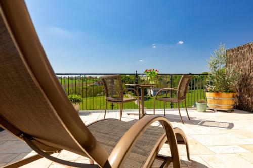 a patio with chairs and a table with a view of the ocean at Weingut und Gästezimmer Perner in Ehrenhausen