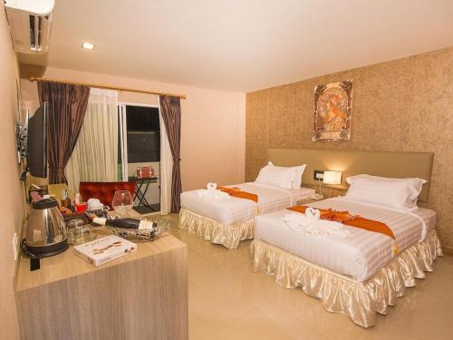 a hotel room with two beds and a television at Retro39 in Bangkok