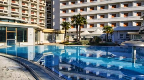 a large swimming pool in front of a building at Hotel Terme Marconi in Montegrotto Terme