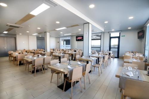 a restaurant with tables and chairs in a room at Hotel Leo in Monesterio