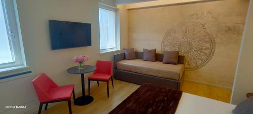 a living room with a couch and two red chairs at TiAMo Modern Design Guest House in Ronchi dei Legionari