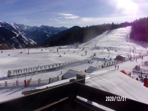 um grupo de pessoas a esquiar numa encosta coberta de neve em Un Isard au Pied des Pistes em Ax-les-Thermes