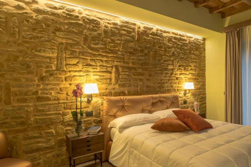 a bedroom with a stone wall with a bed at Villa Antica Dimora intera struttura - Homelike Villas in Deruta