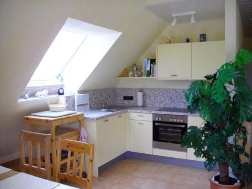 cocina con armarios blancos y ventana grande en Ferienwohnung Am Orpeturm, en Marsberg