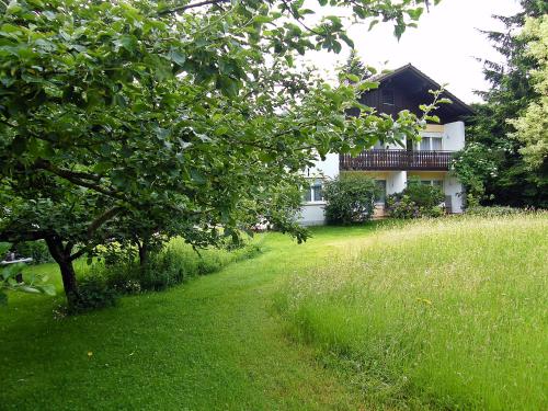 un patio con una casa en el fondo con un árbol en Landhaus Oberrainer, en Bad Griesbach