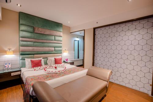 a bedroom with a large bed and a chair at Regenta Inn Jaipur, Adarsh Nagar in Jaipur