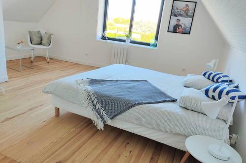a bedroom with a bed and a window at Charming holiday home near top beaches and ports in Penmarcʼh