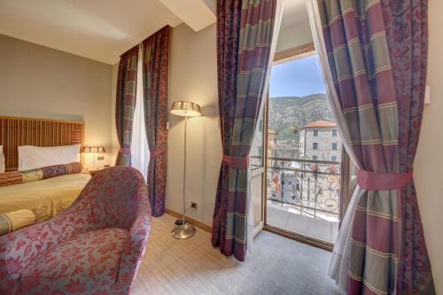 a hotel room with a bed and a balcony at Hotel Vardar in Kotor