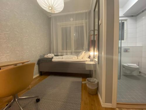 a bedroom with a bed and a bathroom with a shower at Turinge Hotel in Södertälje