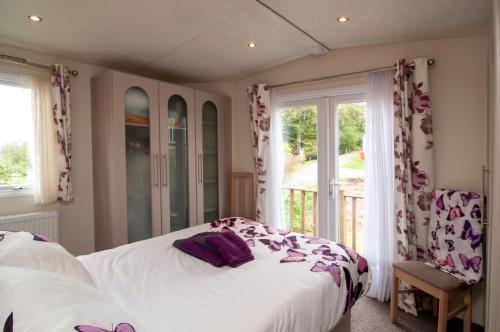 1 dormitorio con cama blanca y ventana en Summer Lodge luxury caravan in Hastings free WiFi, en Hastings
