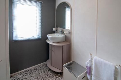 a bathroom with a sink and a mirror at Lodge - Sleeps 6 with Pool Access in Hastings