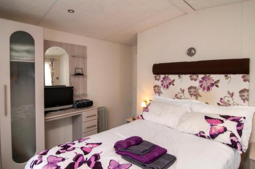 a bedroom with a bed with purple towels on it at Lodge - Sleeps 6 with Pool Access in Hastings