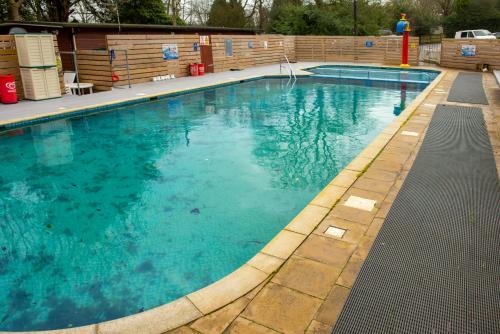 a large swimming pool with blue water at Lodge - Sleeps 6 with Pool Access in Hastings