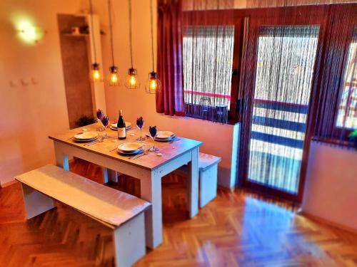 ein Esszimmer mit einem Tisch und Weingläsern darauf in der Unterkunft Holiday Home Bella Vita in Gornji Mihaljevec