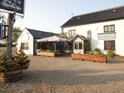 een wit gebouw met een tafel en banken ervoor bij Marsham Arms Inn in Hevingham