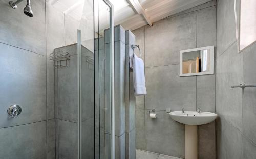 La salle de bains est pourvue d'une douche et d'un lavabo. dans l'établissement Orange River Rafting Lodge, à Kotzeshoop