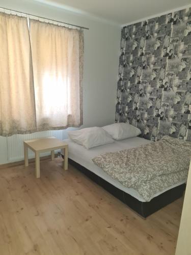 a small bedroom with a bed and a table at Apartament z garażem podziemnym - Augustowska in Olsztyn