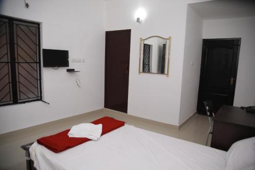 a bedroom with a bed with a mirror and a window at MEGHNA RESIDENCY in Trivandrum