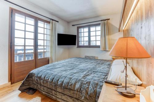 une chambre avec un lit et une table avec une lampe dans l'établissement L'Etoile de Megeve, à Megève