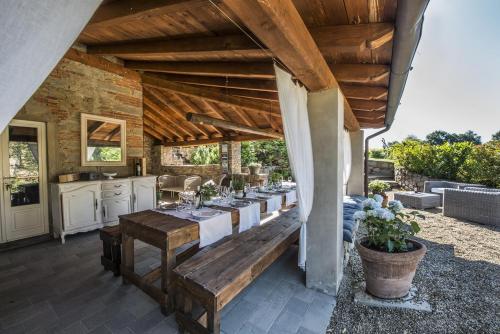 una sala da pranzo all'aperto con tavolo e sedie lunghi di Villa Chianti - Homelike Villas a Terranuova Bracciolini