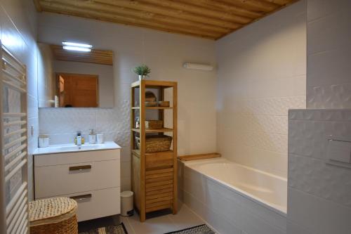 uma casa de banho com uma banheira e um lavatório e uma banheira em VAUJANYLOCATIONS - Saphir 04 em Vaujany
