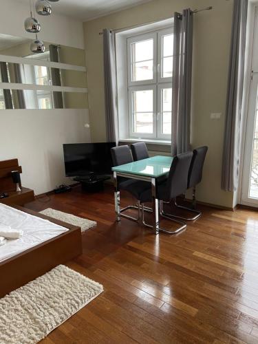 a living room with a glass table and chairs at apartament centrum in Gdynia