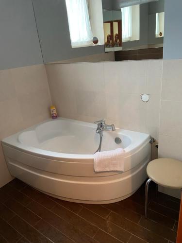 a white bath tub in a bathroom with a stool at apartament centrum in Gdynia