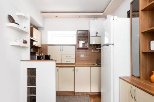 Una cocina con gabinetes blancos y un refrigerador. en Secret House, en Brasov