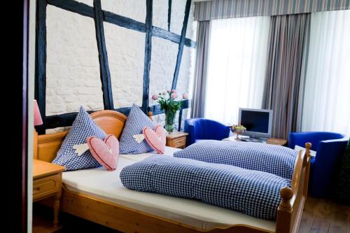a bedroom with two beds with blue and pink pillows at Hotel Alte Laterne in Baden-Baden