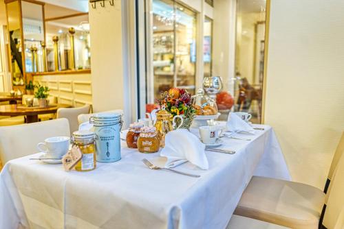 a table with a white table cloth and flowers on it at Hotel Laterne in Baden-Baden
