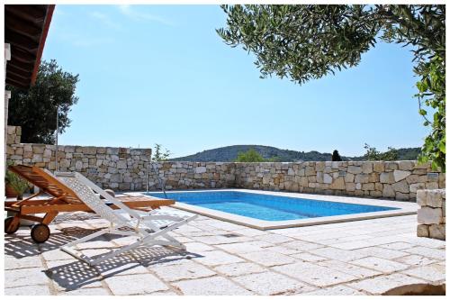 a swimming pool with a lounge chair and a swimming pool at Villa Kate in Vrsine