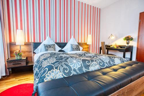 a bedroom with a bed and a red and white striped wall at Suiten Hotel Dependance Laterne in Baden-Baden