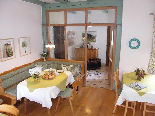 sala de estar con 2 mesas y sofá en Landhaus Oberrainer, en Bad Griesbach