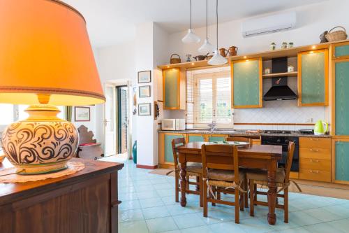 a kitchen with a table with chairs and a lamp at Terrazza Morgera by Napoliapartments in Ischia