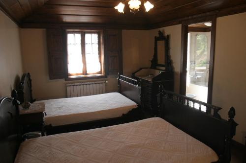 a bedroom with two beds and a mirror and windows at Casa De Carcavelos in Cabeceiras de Basto