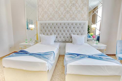 Ramada by Wyndham Plovdiv Trimontium في بلوفديف: غرفة نوم بسريرين مع بعرصي زرقاء