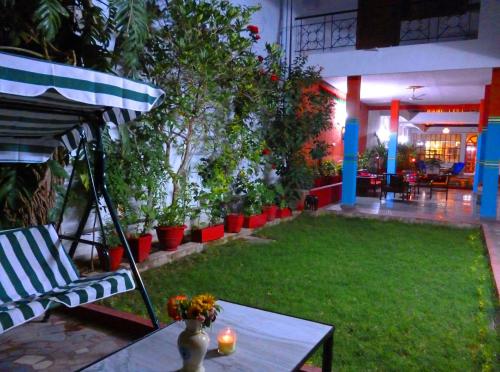 a patio with a table and a chair and plants at Hotel Harmony in Khajurāho