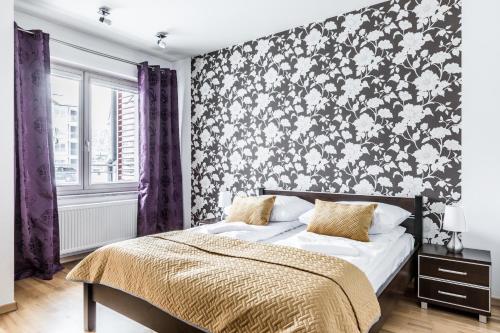 a bedroom with a bed with a black and white floral wallpaper at Apartament Stara Polana Odkryj Zakopane in Zakopane