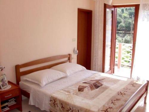 Schlafzimmer mit einem großen Bett und einem Fenster in der Unterkunft Apartments Mira 1434 in Lun
