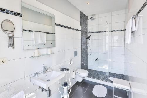 a white bathroom with a sink and a toilet at Hotel zum Goldenen Löwen in Baden-Baden