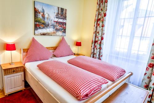 um quarto com uma cama com almofadas vermelhas e brancas em Hotel zum Goldenen Löwen em Baden-Baden
