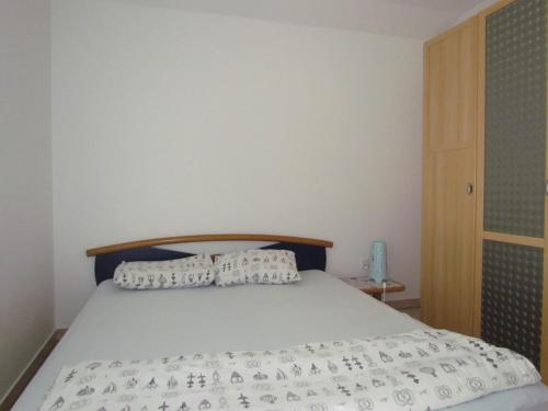 a bed with white sheets and pillows on it at Holiday house Damir in Sveti Filip i Jakov