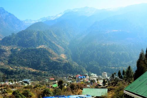 a town in a valley with mountains in the background at Rufina Lachung de'CROWN in Lachung