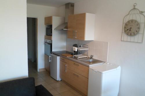 une petite cuisine avec un évier et un réfrigérateur dans l'établissement Appartement vue mer et montagne, à Calvi