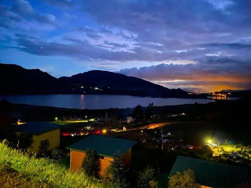 a view of a city and a lake at night at Refugio del Neusa in Cogua