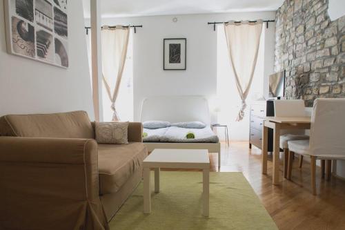 a living room with a couch and a table at Apartments Artemus Music in Piran