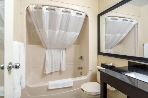 a bathroom with a tub and a toilet and a sink at Comfort Inn Parry Sound in Parry Sound