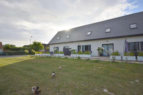 a house with some birds standing in the yard at Gite L'Echo des 2 Baies in Saint-Quentin-en-Tourmont