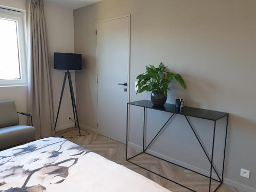 a bedroom with a bed and a plant on a table at Snooze in Ostend