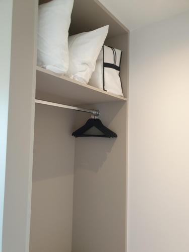 a closet with white pillows and a shelf at Snooze in Ostend